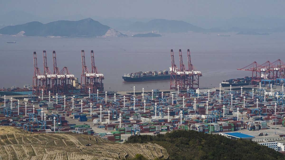 Container cranes and stacked shipping containers at a Ningbo-Zhoushan Port terminal in Zhejiang province, China