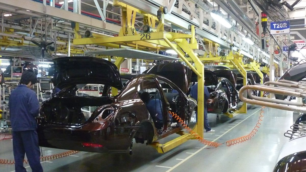 Workers and robots on a Geely car assembly line in Ningbo, China