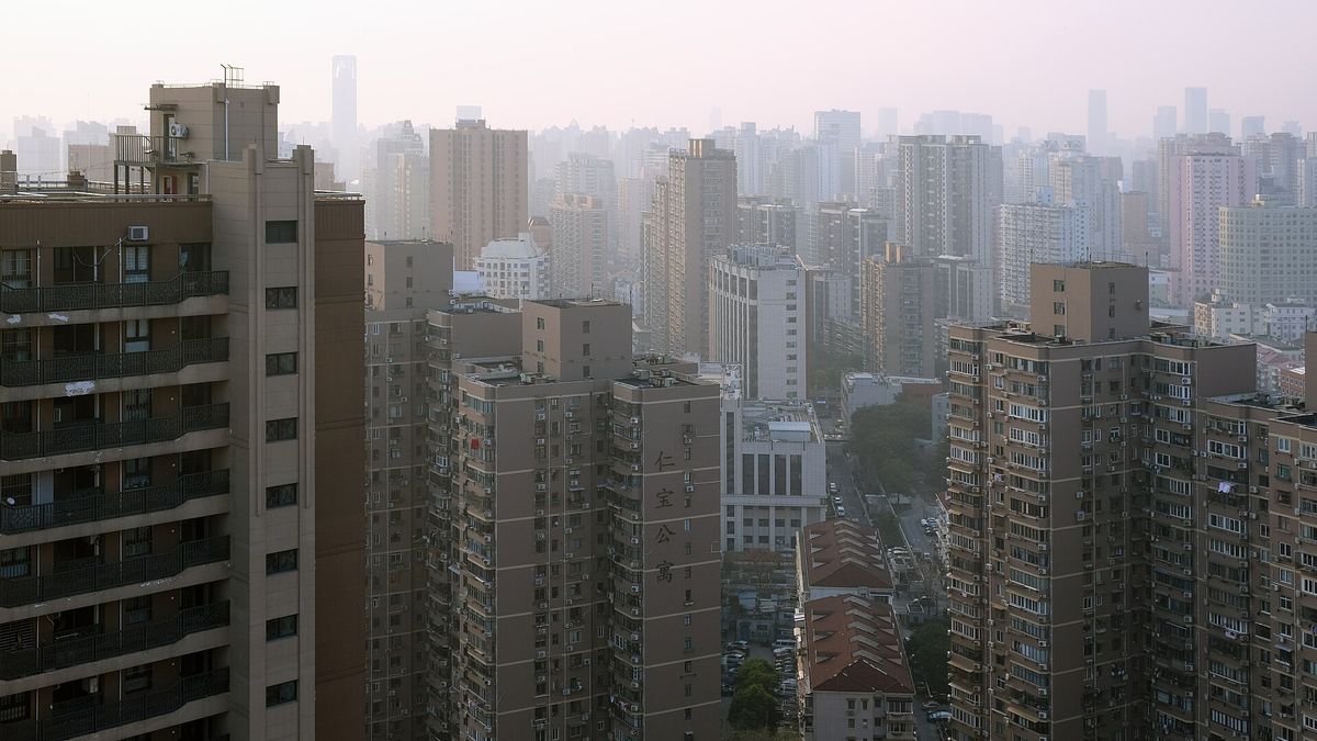 Rows of high-rise apartment blocks in Shanghai under a hazy sky