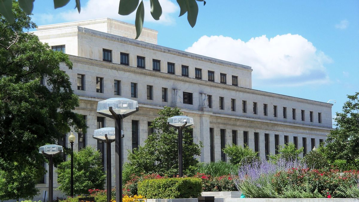 The Marriner S. Eccles Federal Reserve Board Building in Washington behind trees and gardens
